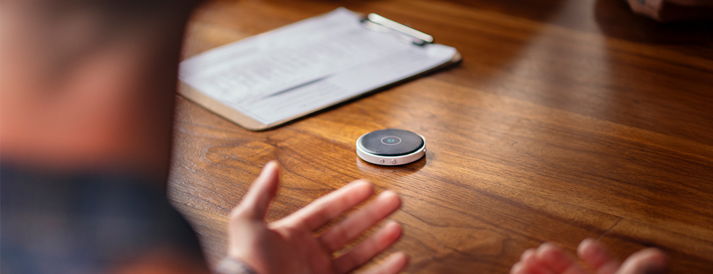 Behind view of man talking at a table with a Table Microphone in front of him